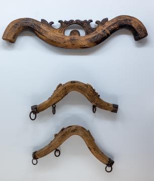 Jarem za živinsko vprego, 19. st., dekorativno oblikovan, žgan les; spodaj na sliki: dva jarmička za kravo, 19. st., rezbarski motivi, les.